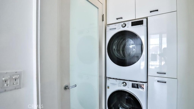 washroom featuring stacked washer / drying machine