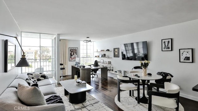 living room featuring baseboards, wood finished floors, and a chandelier