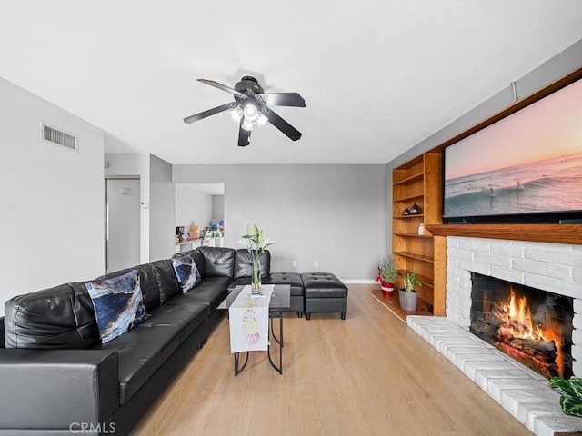 10478 Nutmeg St, Rancho Cucamonga, CA 91730 - living room featuring ceiling fan, visible vents, a fireplace, baseboards, and light wood-style flooring