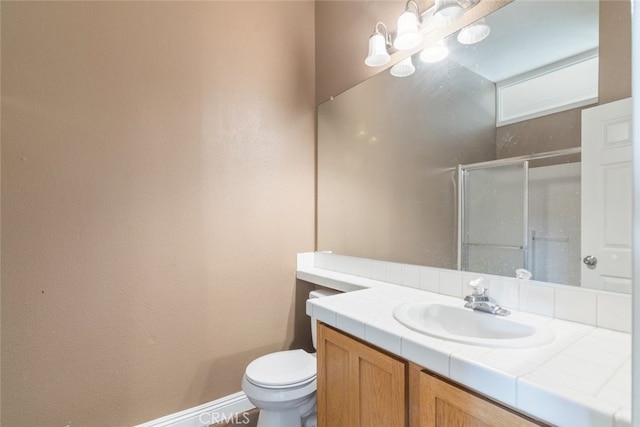 full bathroom with vanity, baseboards, a stall shower, and toilet