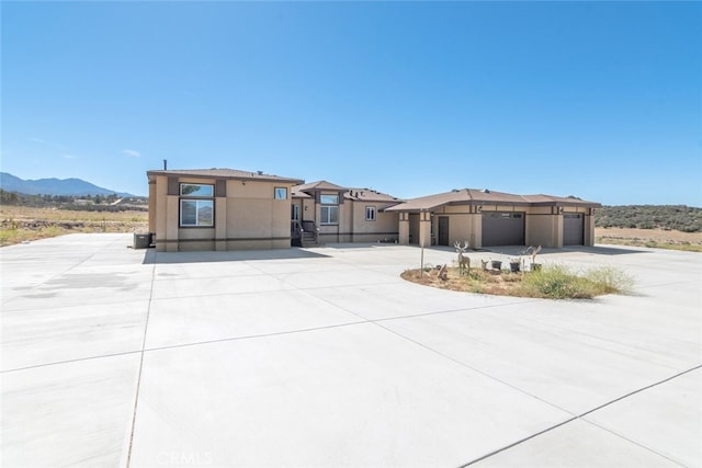 view of front of home featuring an attached garage, driveway, and a mountain view