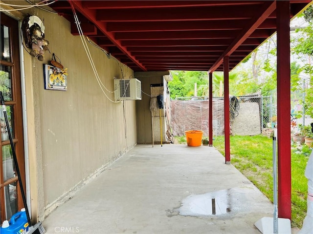 view of patio / terrace featuring a wall mounted AC and fence