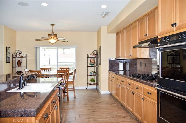 kitchen featuring decorative backsplash, ceiling fan, a sink, black appliances, and under cabinet range hood