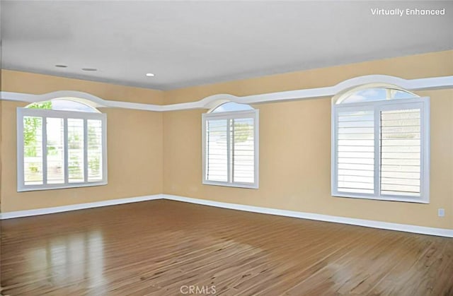empty room featuring baseboards, recessed lighting, and wood finished floors