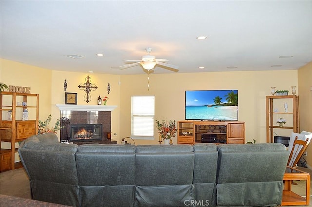 living room with ceiling fan, a fireplace, recessed lighting, and visible vents