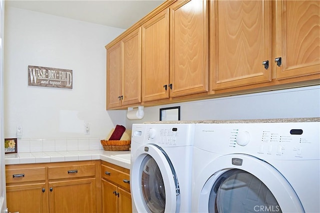 washroom with cabinet space and washing machine and clothes dryer
