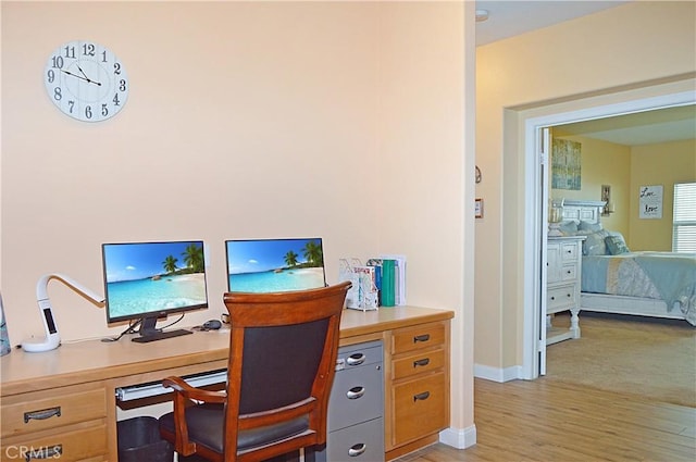 office space featuring baseboards and light wood-style flooring