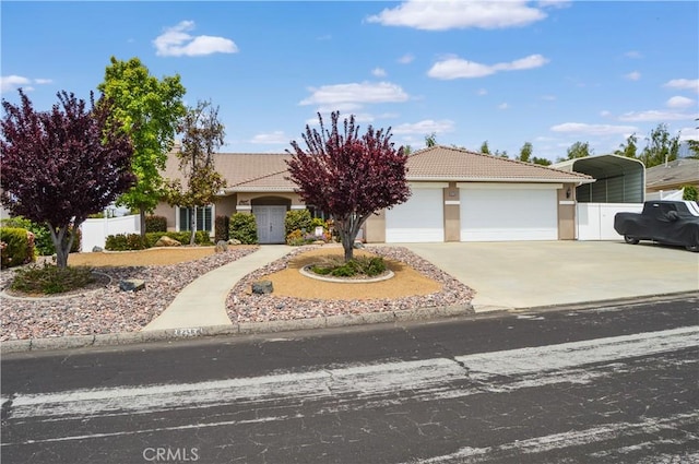 view of front facade featuring fence, stucco siding, a tiled roof, concrete driveway, and an attached garage