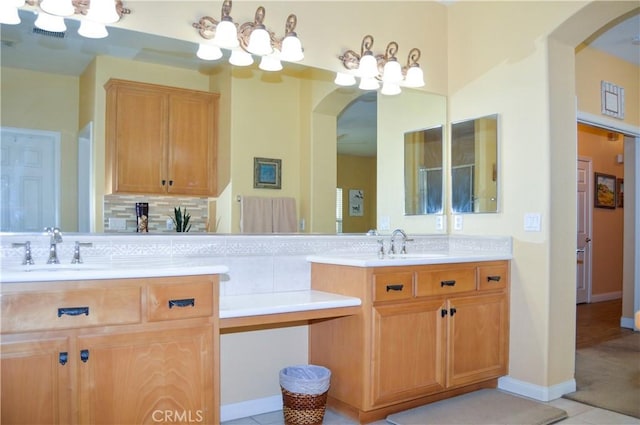 full bathroom with double vanity, a sink, backsplash, and a chandelier