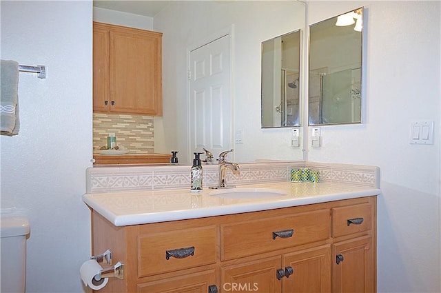 bathroom with vanity, tasteful backsplash, and toilet