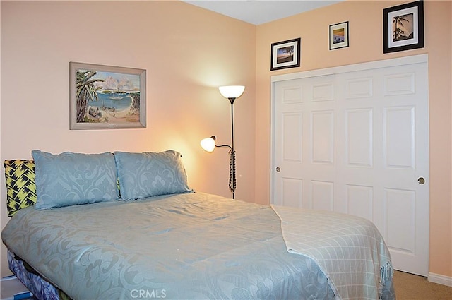bedroom with baseboards, carpet, and a closet