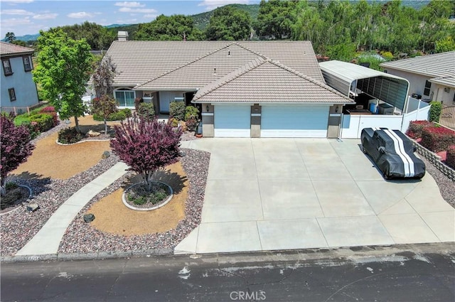 ranch-style house featuring a garage, stucco siding, driveway, and a tile roof
