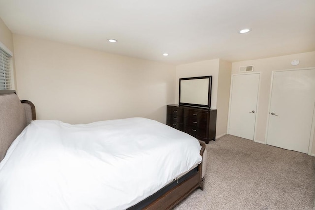 bedroom with light colored carpet, recessed lighting, and visible vents