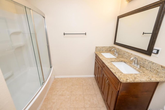 full bath featuring double vanity, baseboards, a sink, and tile patterned flooring