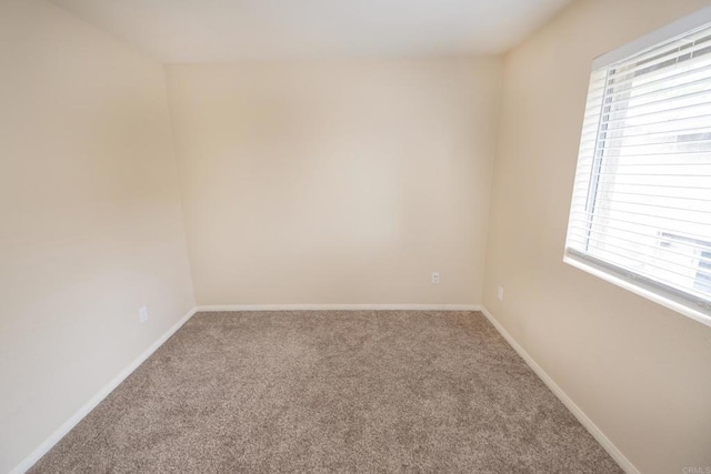 carpeted empty room with baseboards