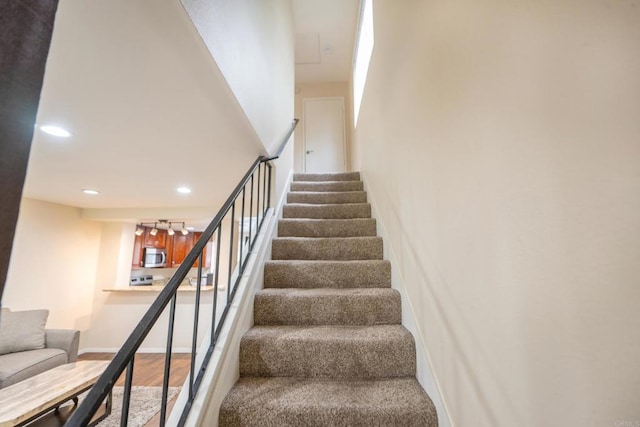 stairs featuring recessed lighting and wood finished floors