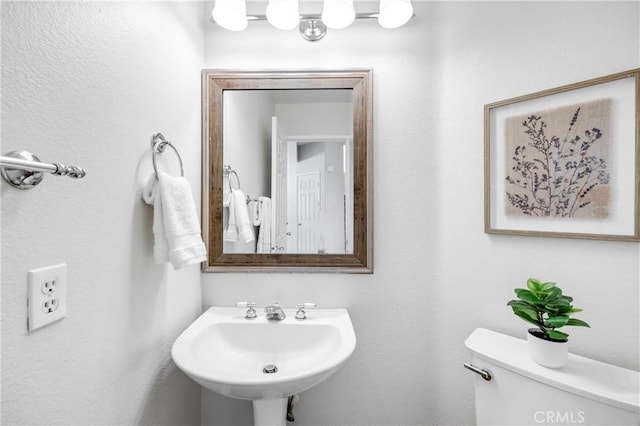 half bath featuring a sink and toilet