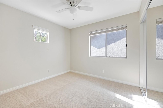unfurnished room featuring baseboards and light colored carpet