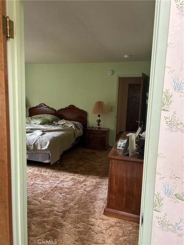 bedroom featuring a textured ceiling and carpet