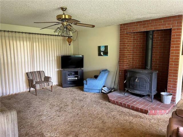 carpeted living area featuring a wood stove, a ceiling fan, and a textured ceiling