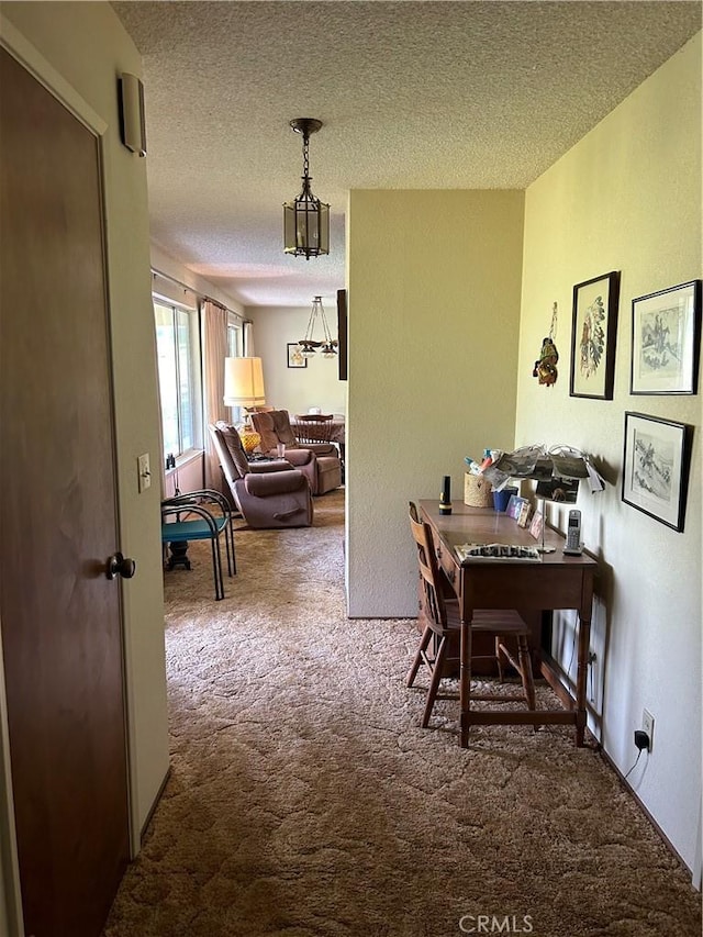 carpeted dining space featuring a textured ceiling and a notable chandelier