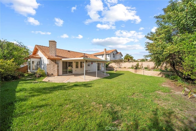 rear view of property with a patio, fence, a tile roof, and a chimney