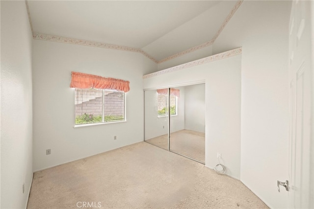 unfurnished bedroom with vaulted ceiling, carpet, and a closet
