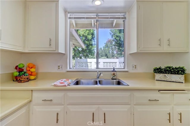125 Via Estrada Unit B, Laguna Woods, CA 92637 - kitchen with light countertops, white cabinetry, a wealth of natural light, and a sink