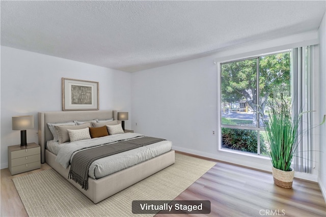 125 Via Estrada Unit B, Laguna Woods, CA 92637 - bedroom with a textured ceiling, baseboards, and wood finished floors