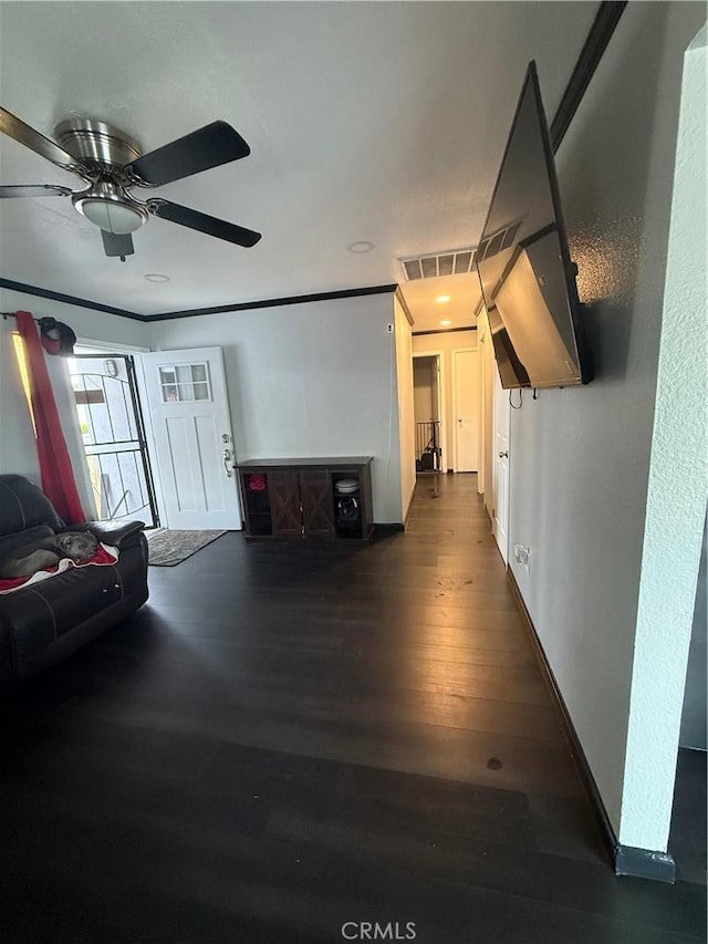 living area with visible vents, a ceiling fan, baseboards, and dark wood-type flooring