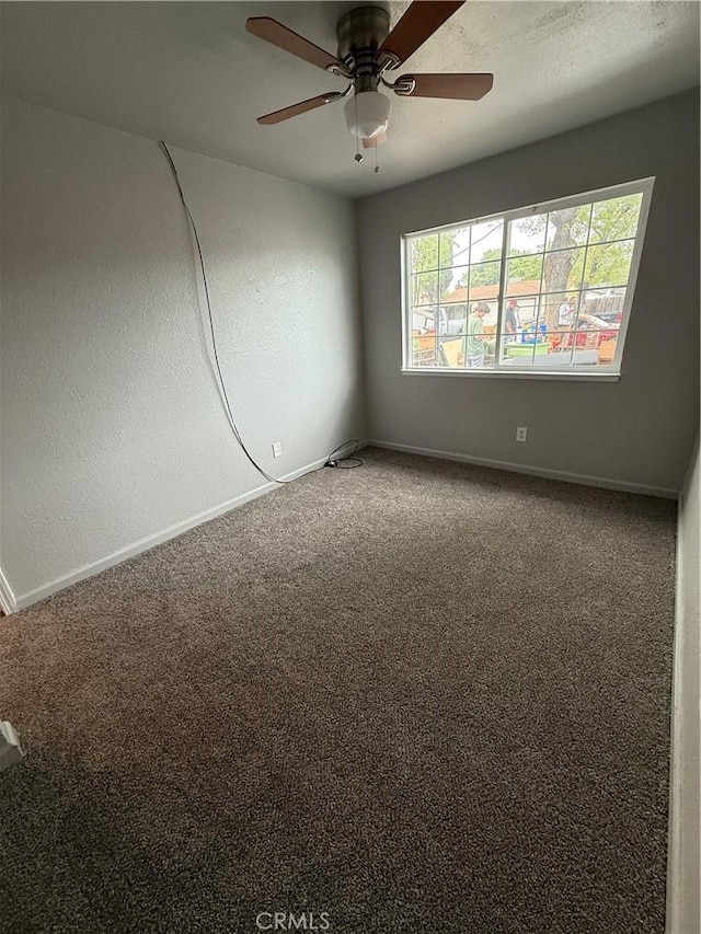 spare room featuring baseboards, a ceiling fan, and carpet