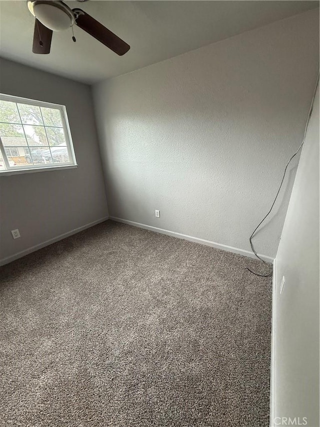 empty room featuring carpet flooring, a ceiling fan, and baseboards
