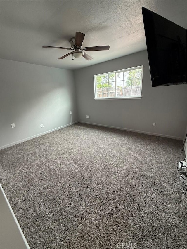 unfurnished room with baseboards, a ceiling fan, and carpet
