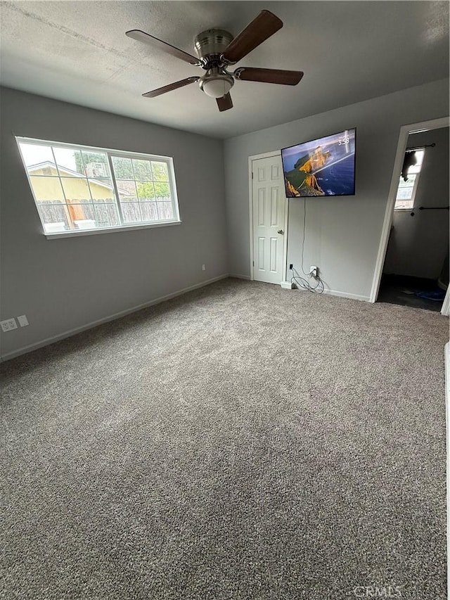 unfurnished bedroom featuring baseboards, carpet floors, a closet, and ceiling fan