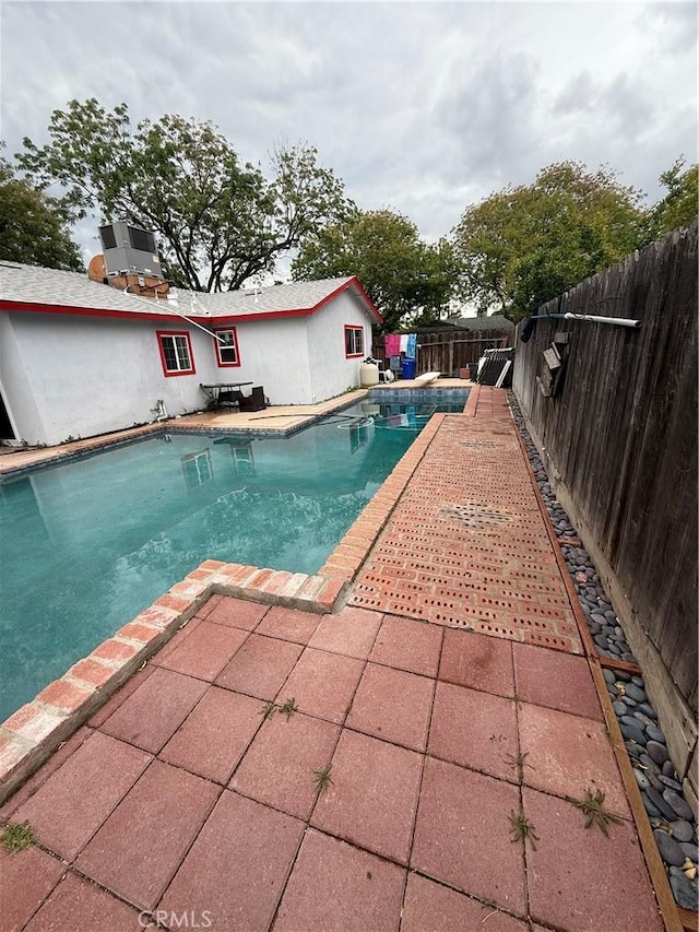 view of swimming pool with a fenced in pool, a fenced backyard, and a patio area