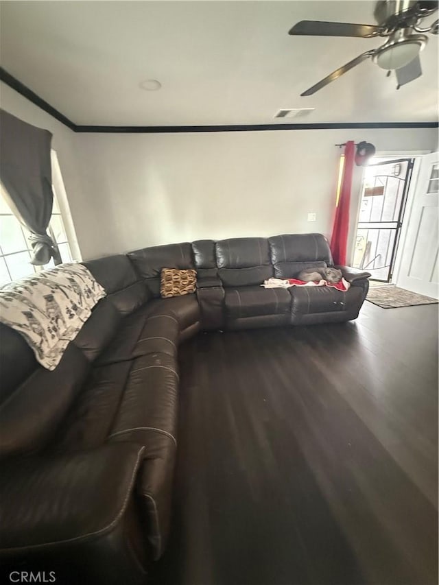 living area with crown molding, ceiling fan, wood finished floors, and visible vents