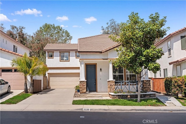 view of front of property featuring concrete driveway, a tiled roof, stone siding, and stucco siding