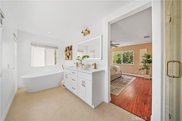 ensuite bathroom with visible vents, a sink, and baseboards