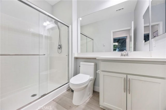full bathroom featuring toilet, visible vents, a shower stall, and wood finished floors