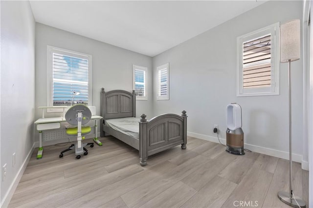 bedroom with baseboards and light wood finished floors