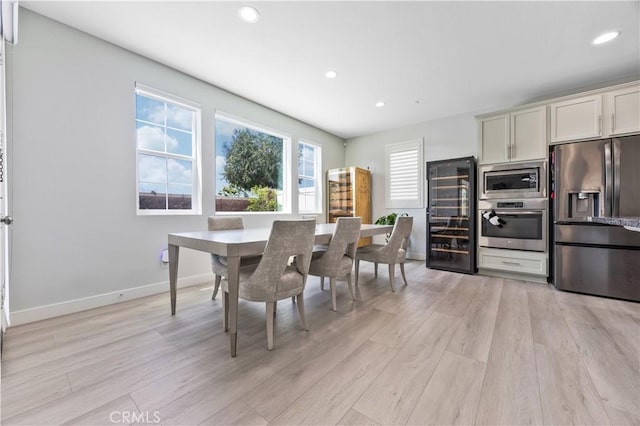 dining room featuring recessed lighting, baseboards, light wood-style flooring, and wine cooler