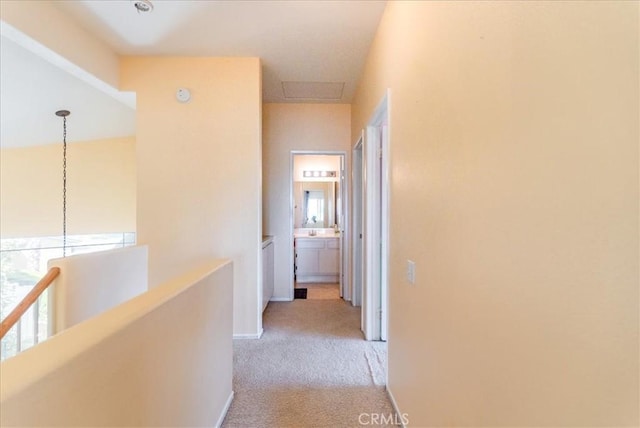 hallway with light carpet and an upstairs landing