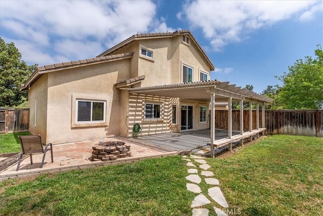 back of house with a yard, a pergola, a fire pit, and a fenced backyard