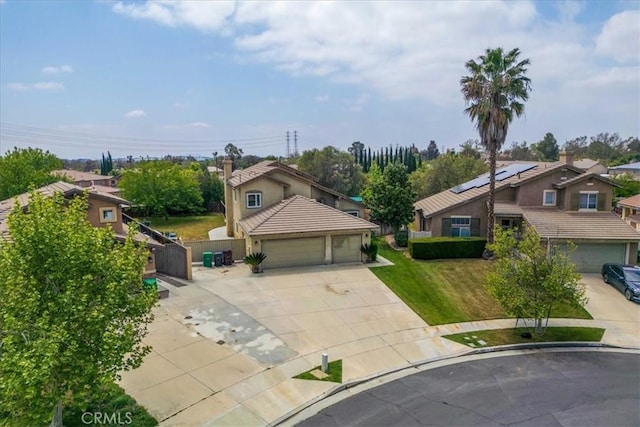 traditional-style home with driveway, a front yard, a residential view, fence, and stucco siding