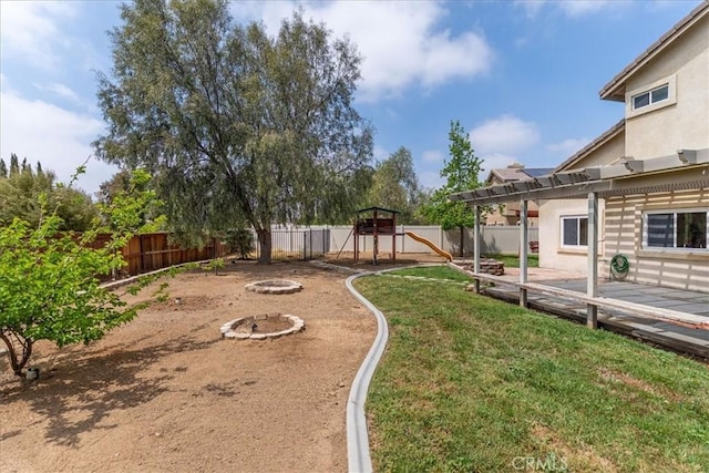 view of yard featuring a playground, a pergola, a fenced backyard, and an outdoor fire pit