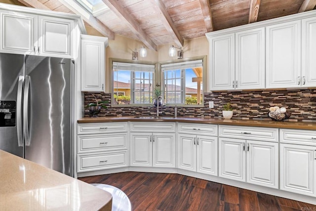 kitchen featuring stainless steel refrigerator with ice dispenser, tasteful backsplash, a sink, wooden ceiling, and beamed ceiling