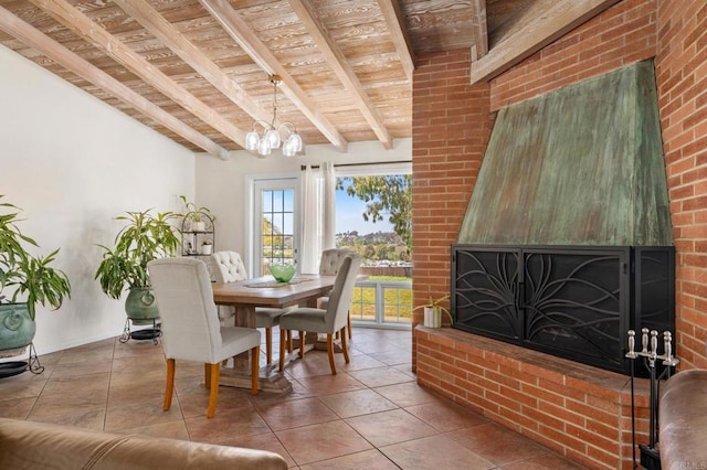 dining room featuring a brick fireplace, beam ceiling, wood ceiling, tile patterned floors, and a notable chandelier