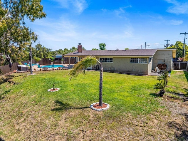 exterior space with a fenced in pool, a fenced backyard, a yard, and a chimney