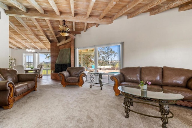 carpeted living area with ceiling fan, a brick fireplace, high vaulted ceiling, beamed ceiling, and wood ceiling