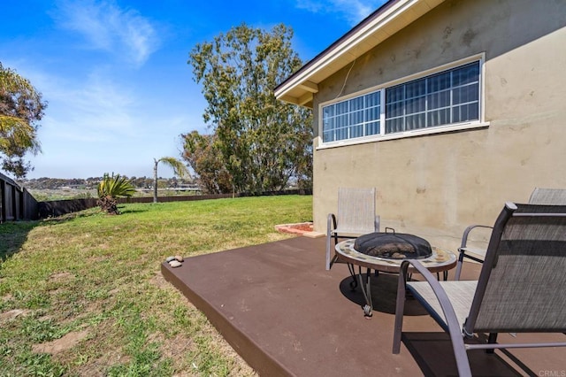 view of yard featuring a patio, an outdoor fire pit, and fence